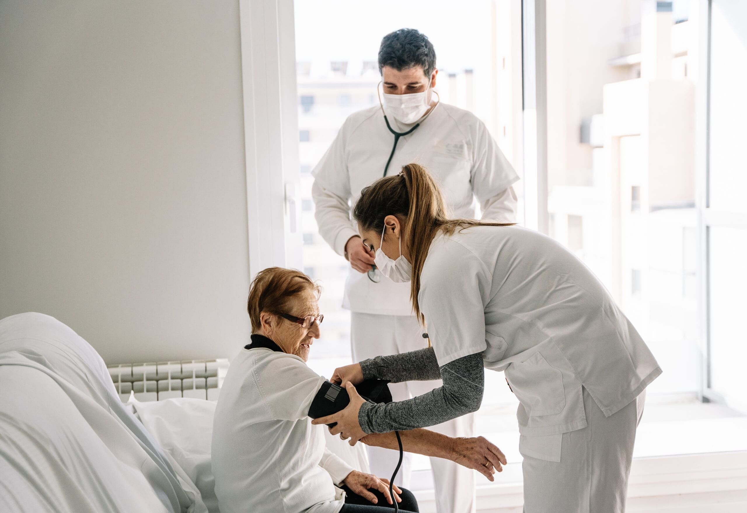 doctors-diagnosing-blood-pressure-of-senior-woman-2023-11-27-04-58-28-utc-scaled-min