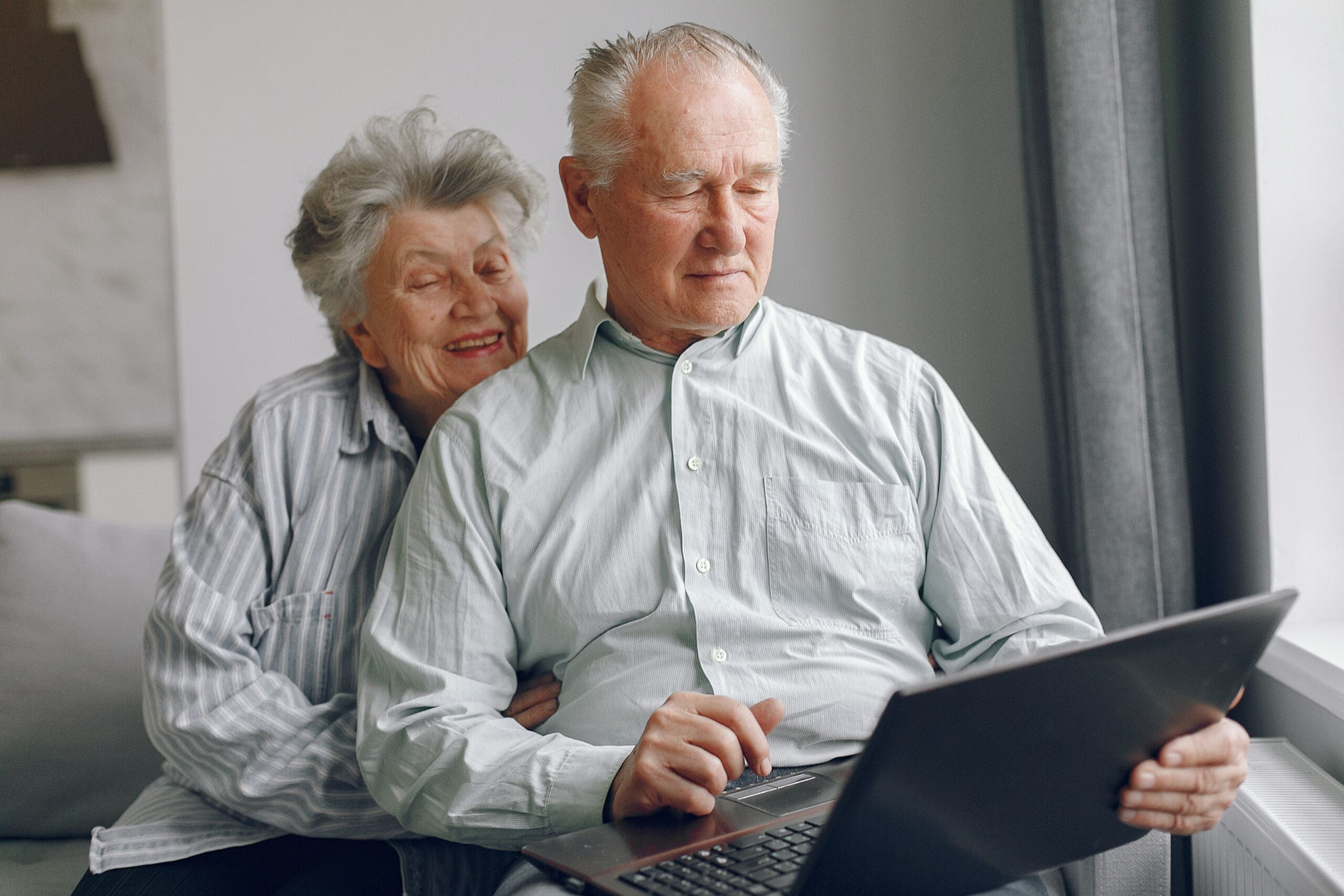 elegant-old-couple-sitting-at-home-and-using-a-lap-2023-11-27-04-52-02-utc-scaled-min
