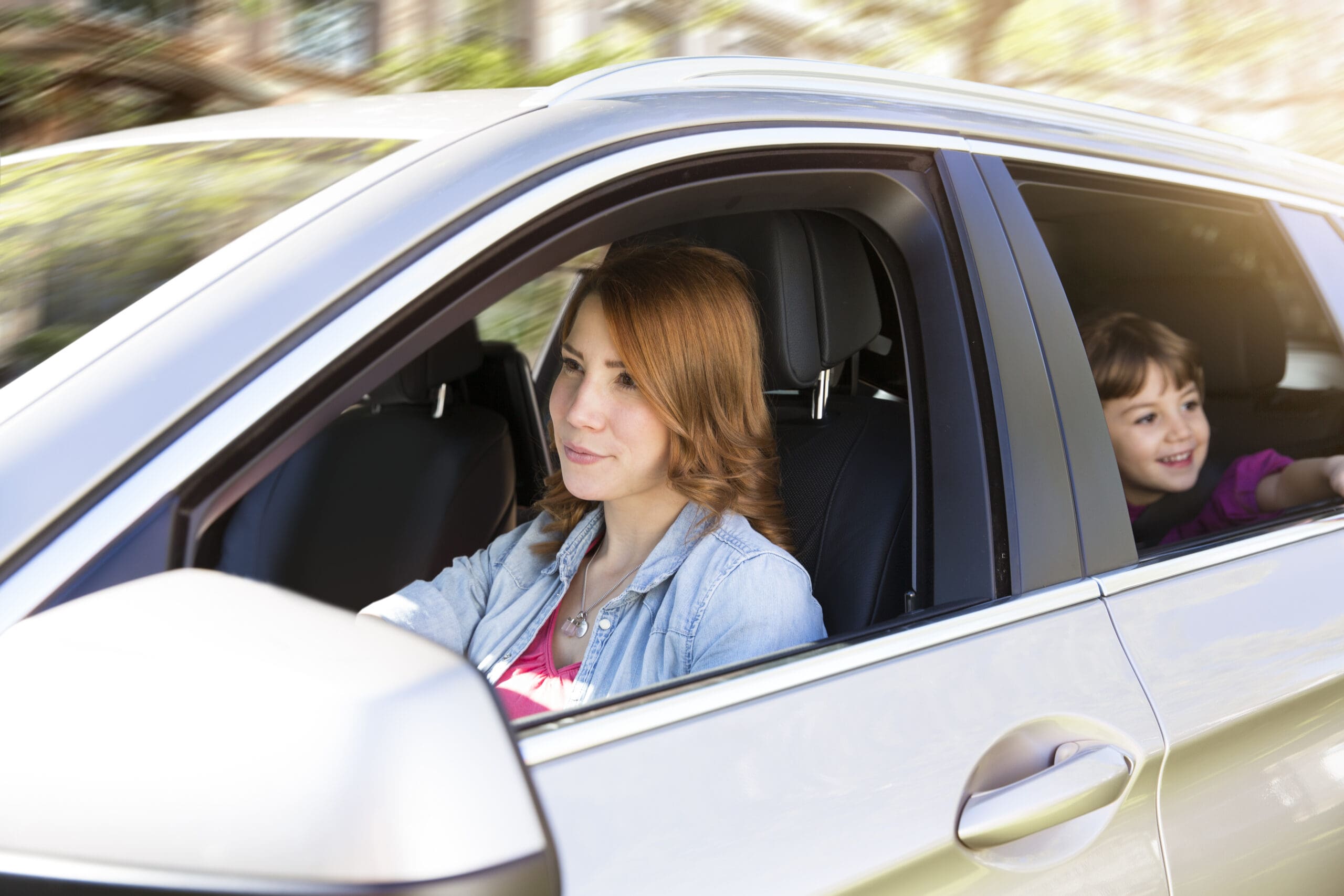 woman-driving-car-with-girl-on-backseat-2023-11-27-05-32-44-utc-scaled-min